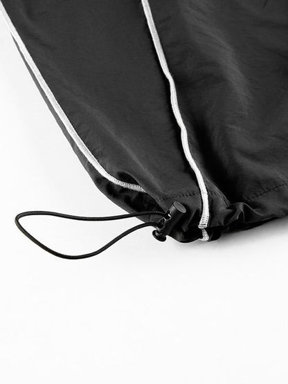 Zwarte parachutebroek met cargozakken en biezendetail